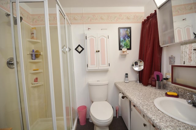 bathroom with toilet, vanity, and walk in shower