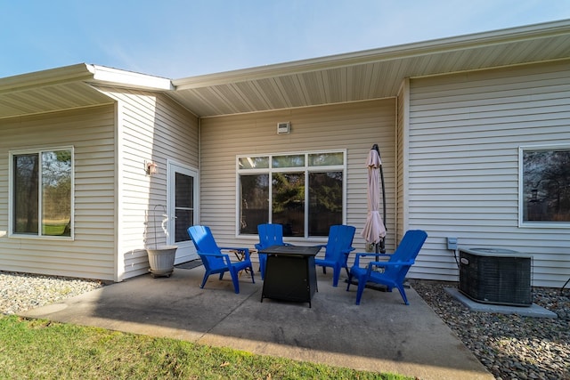 view of patio featuring central air condition unit and a fire pit