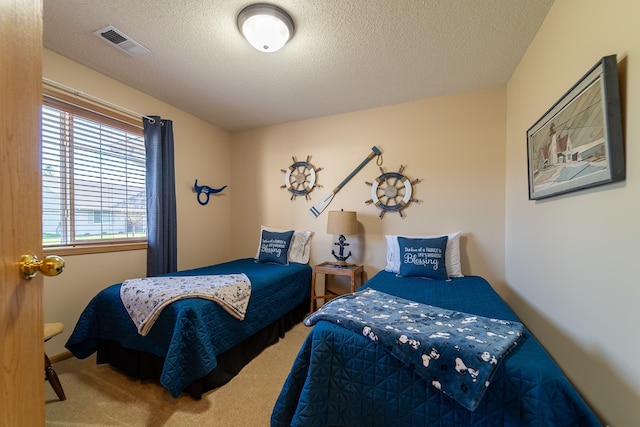 bedroom featuring a textured ceiling, visible vents, and carpet flooring