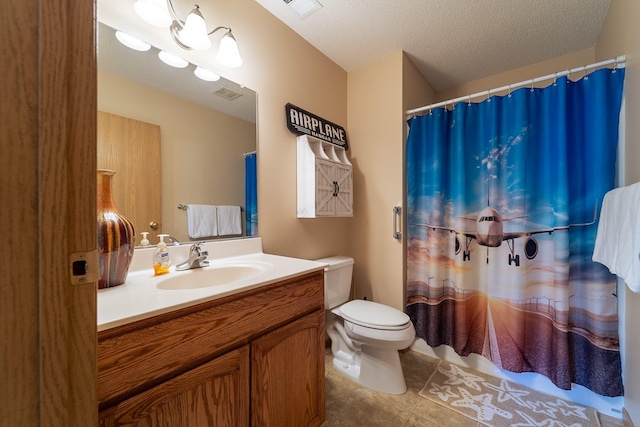 bathroom with a textured ceiling, toilet, vanity, visible vents, and tile patterned floors