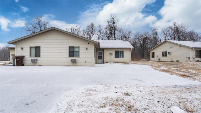 snow covered house featuring a wall mounted AC