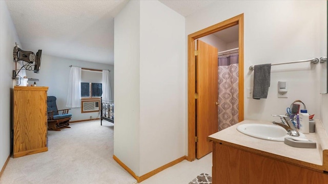 full bath with a textured ceiling, baseboards, and vanity