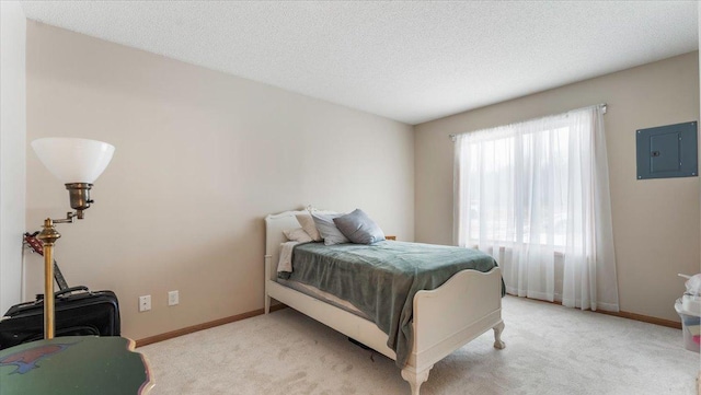 bedroom with electric panel, baseboards, a textured ceiling, and light colored carpet