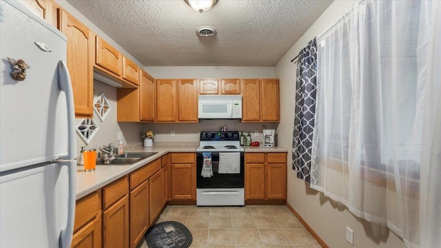 kitchen with white appliances, visible vents, light countertops, a sink, and light tile patterned flooring