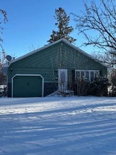 snow covered property with a garage