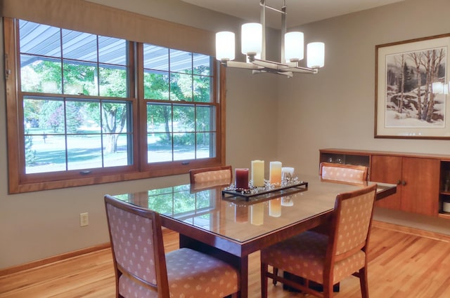 dining area with a wealth of natural light, a chandelier, and light hardwood / wood-style floors