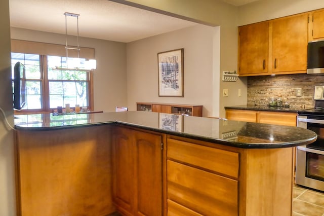 kitchen with dark stone countertops, light tile patterned floors, backsplash, pendant lighting, and appliances with stainless steel finishes