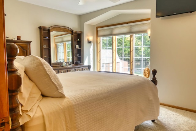 bedroom with ceiling fan, vaulted ceiling, and carpet