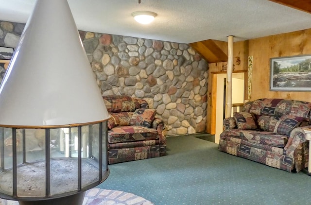 living room featuring wooden walls, a textured ceiling, and carpet