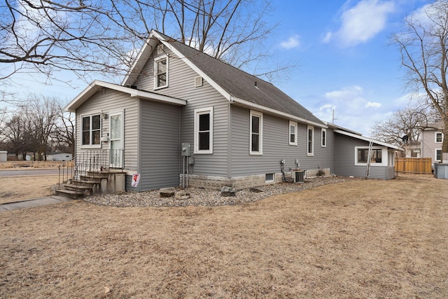 view of property exterior featuring fence and a shingled roof