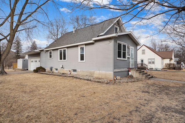 view of side of property featuring a garage, a chimney, and a shingled roof