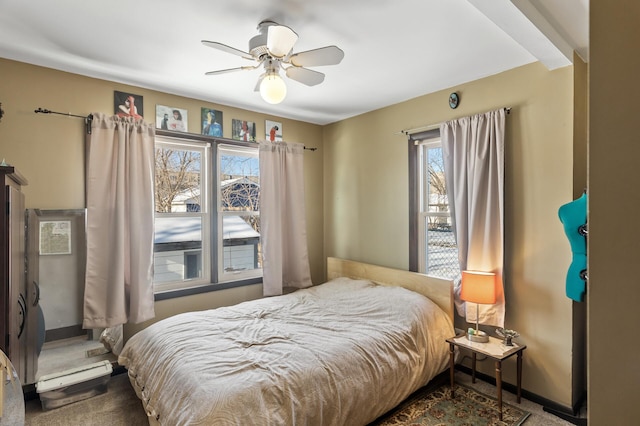 carpeted bedroom with ceiling fan and baseboards