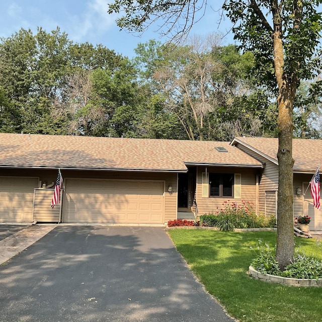 ranch-style home featuring a garage and a front lawn