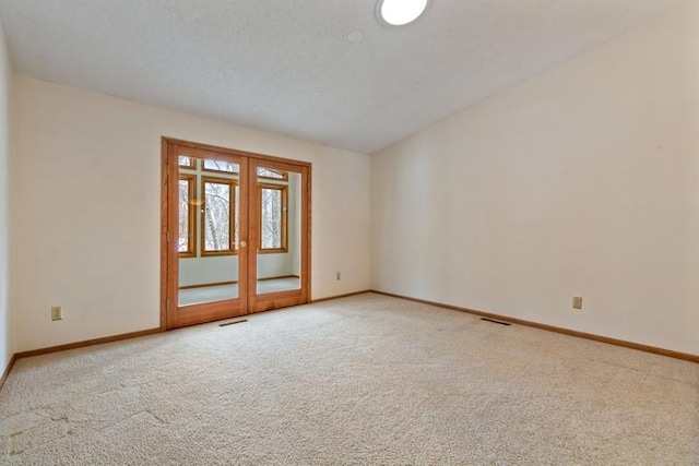 carpeted empty room featuring vaulted ceiling