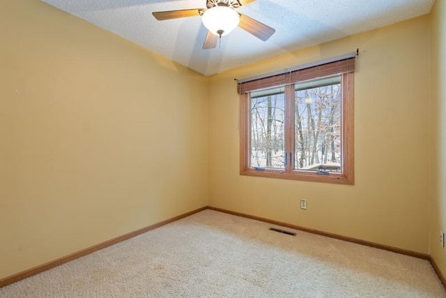 carpeted empty room featuring ceiling fan and a textured ceiling