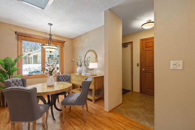 dining area featuring a textured ceiling and light wood-type flooring