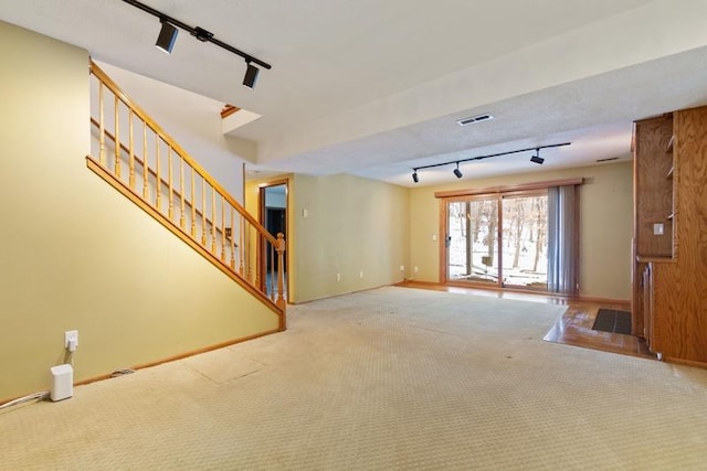 unfurnished living room with track lighting and carpet flooring