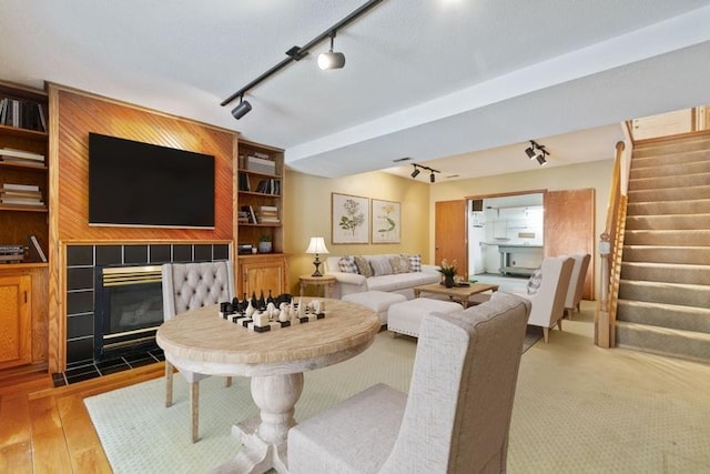 living room with wood-type flooring and a tile fireplace