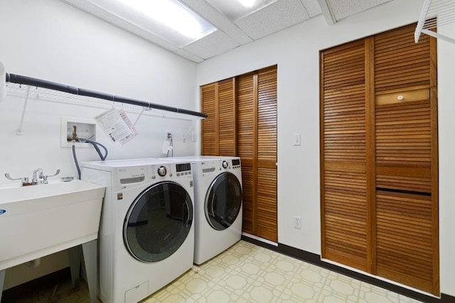 clothes washing area with sink and independent washer and dryer