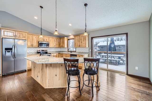 kitchen featuring stainless steel appliances, tasteful backsplash, dark hardwood / wood-style flooring, vaulted ceiling, and a center island