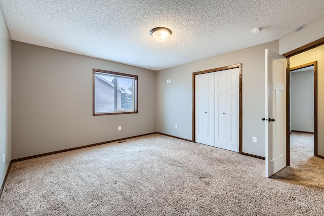 unfurnished bedroom with carpet, a closet, and a textured ceiling