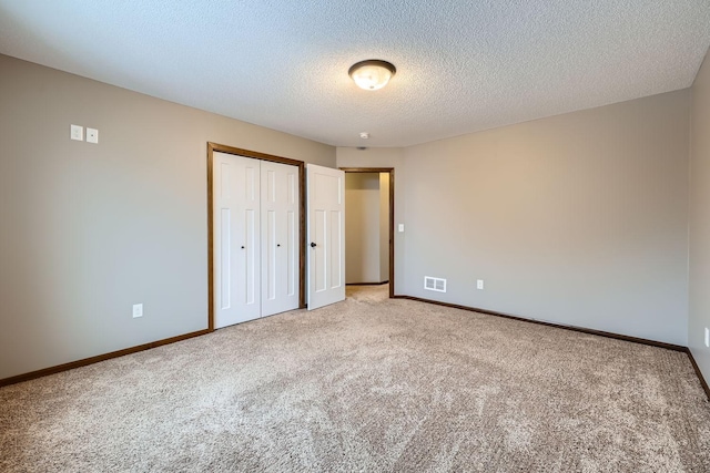 unfurnished bedroom featuring carpet, a closet, and a textured ceiling