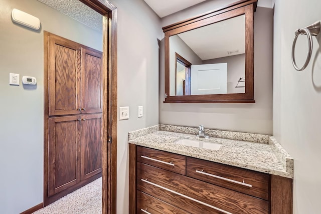 bathroom with a textured ceiling and vanity