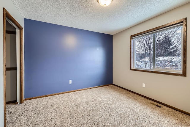 spare room with carpet floors and a textured ceiling