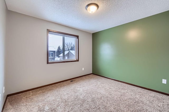 unfurnished room featuring carpet floors and a textured ceiling