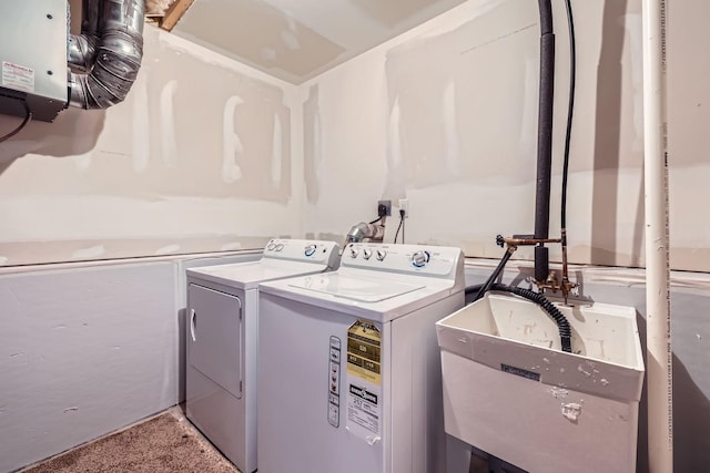 clothes washing area featuring sink, carpet, and independent washer and dryer