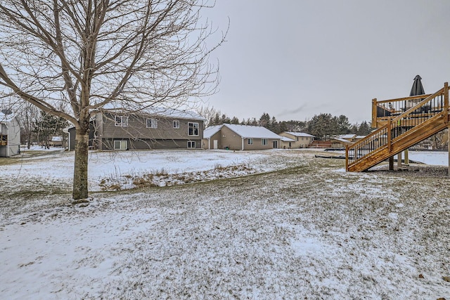 yard covered in snow with a deck