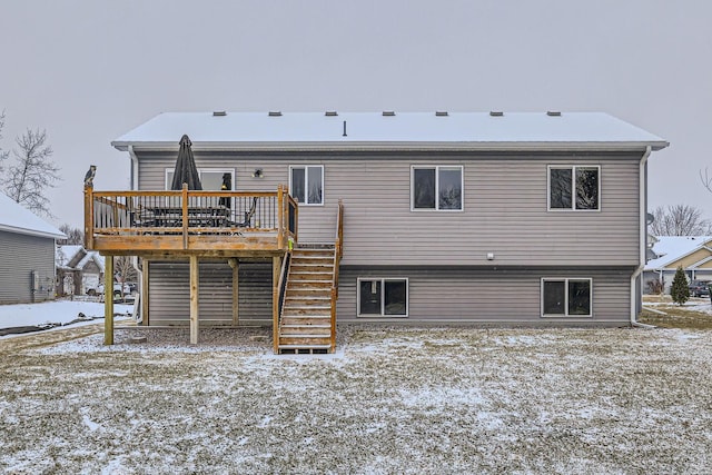 snow covered house featuring a wooden deck