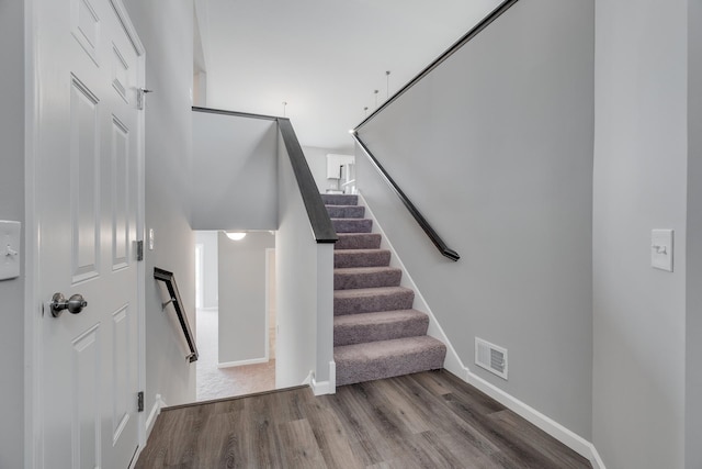 stairs featuring hardwood / wood-style floors