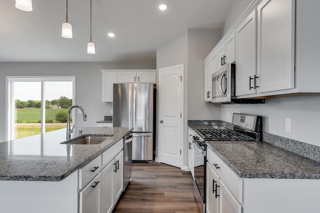 kitchen featuring stainless steel appliances, white cabinetry, sink, and pendant lighting