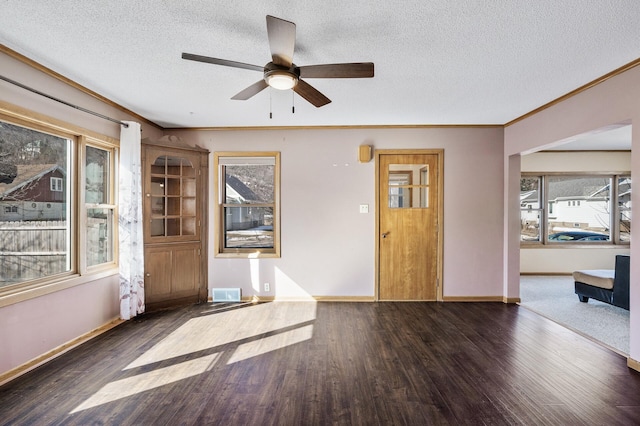 entryway with baseboards, wood finished floors, visible vents, and ornamental molding