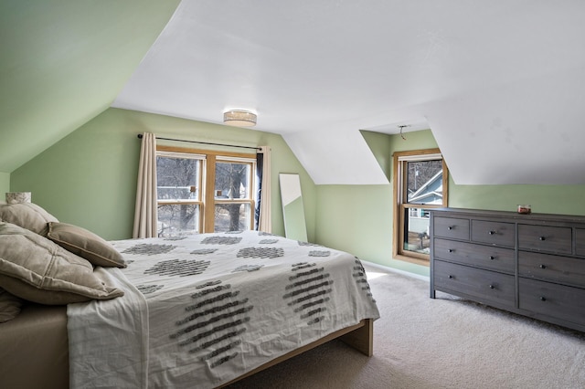 carpeted bedroom with baseboards, multiple windows, and vaulted ceiling