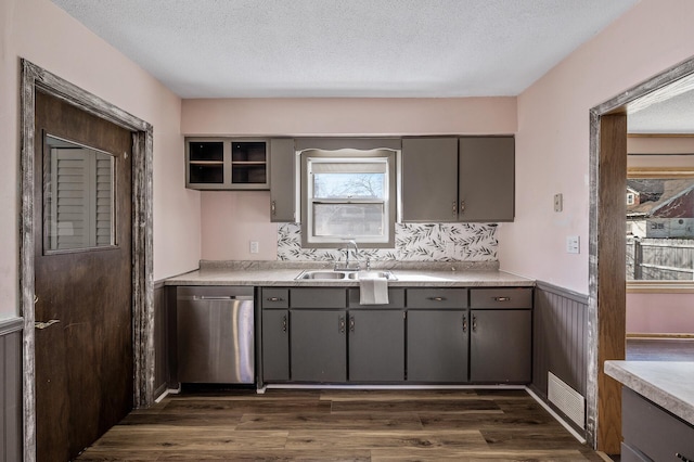 kitchen with a sink, gray cabinetry, and stainless steel dishwasher