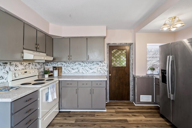 kitchen featuring dark wood-type flooring, gray cabinetry, stainless steel refrigerator with ice dispenser, under cabinet range hood, and white electric stove