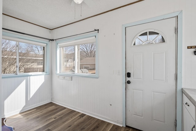 foyer featuring a ceiling fan, ornamental molding, wood finished floors, and a textured ceiling