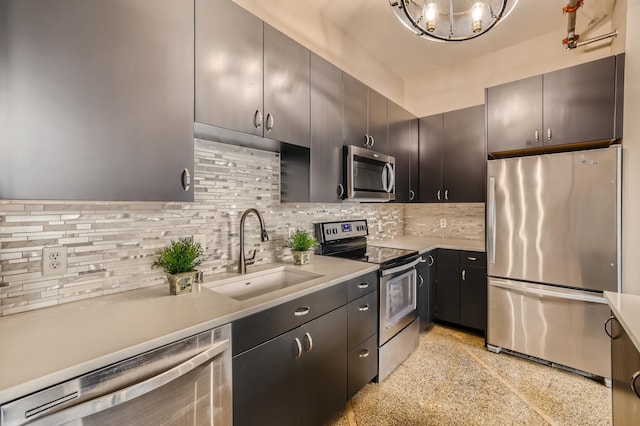 kitchen with stainless steel appliances, a notable chandelier, decorative backsplash, and sink