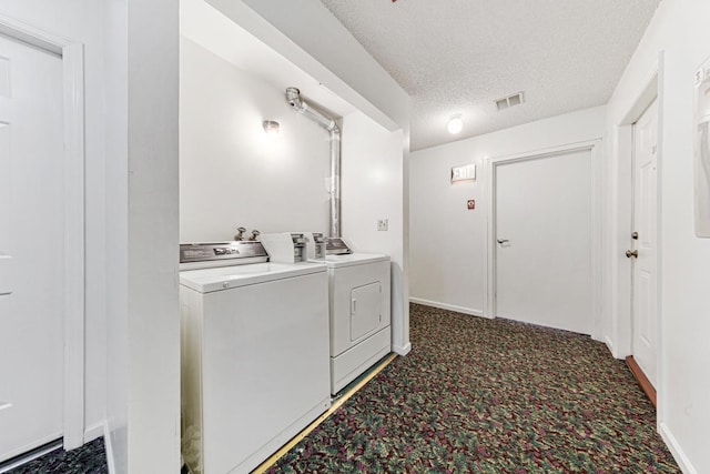 laundry room featuring independent washer and dryer, a textured ceiling, and dark carpet