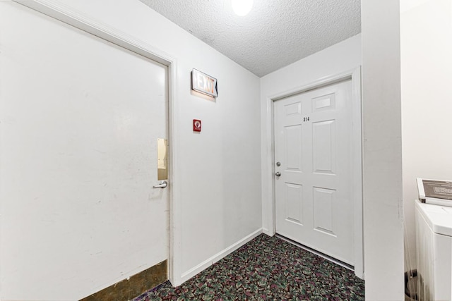 entryway featuring washer / clothes dryer and a textured ceiling