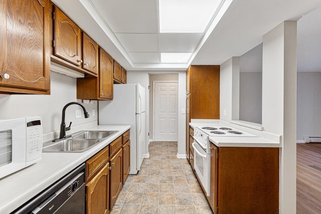 kitchen with sink, white appliances, and a baseboard radiator