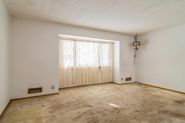 empty room with a textured ceiling and carpet