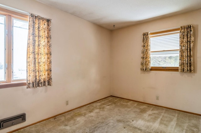 carpeted spare room featuring a healthy amount of sunlight