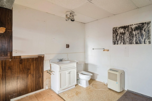 bathroom with toilet, a drop ceiling, and vanity