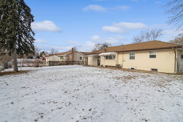 snow covered rear of property with central air condition unit