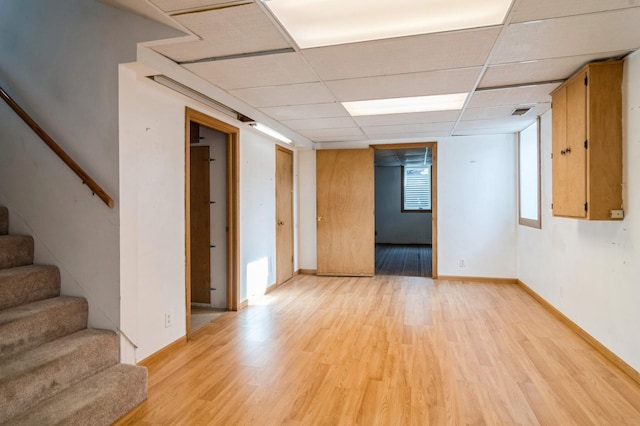 empty room with light wood-type flooring and a drop ceiling