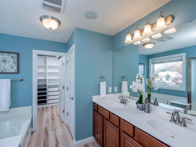 bathroom with a tub to relax in, hardwood / wood-style flooring, and vanity