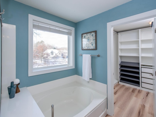 bathroom featuring a tub to relax in and wood-type flooring